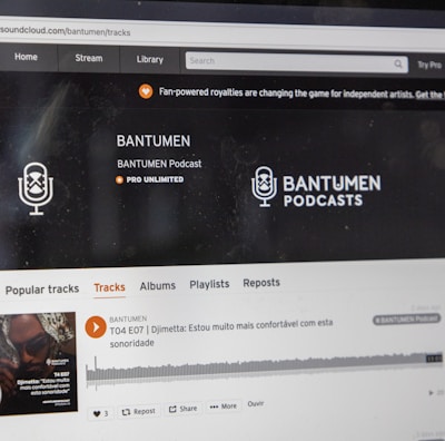A computer screen displaying a website of an audio streaming service. The website showcases a podcast called BANTUMEN with the description 'Pro Unlimited.' There is a navigation bar with options including Home, Stream, Library, and more. A music wave graphic is visible below, along with a play button, social media interaction options such as re-post, share, and add to playlists. A banner at the top talks about fan-powered royalties, and there is a COVID-19 information widget to the side.